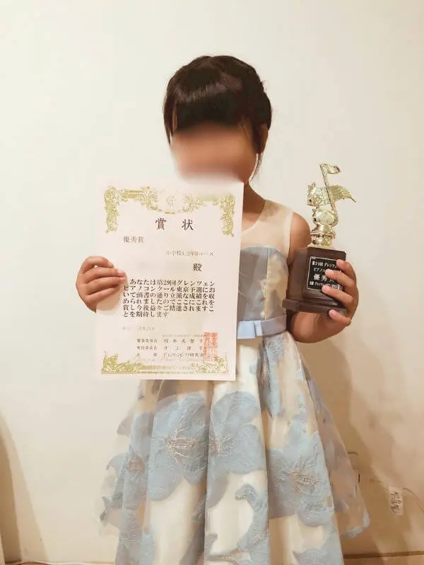 小山市のピアノ教室N piano music schoolに通う生徒が、ピアノコンクールで賞状とトロフィーを受賞した記念写真(ブルードレス)