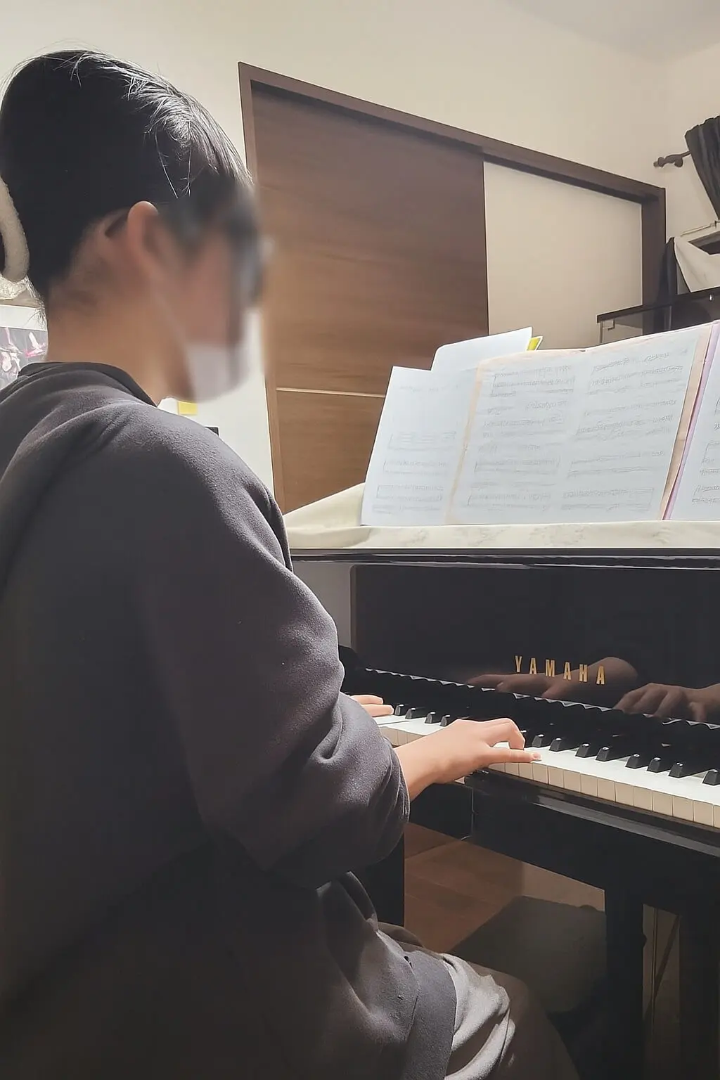 卒業式のピアノ伴奏に向けて練習しているN piano music schoolの生徒の後ろ姿