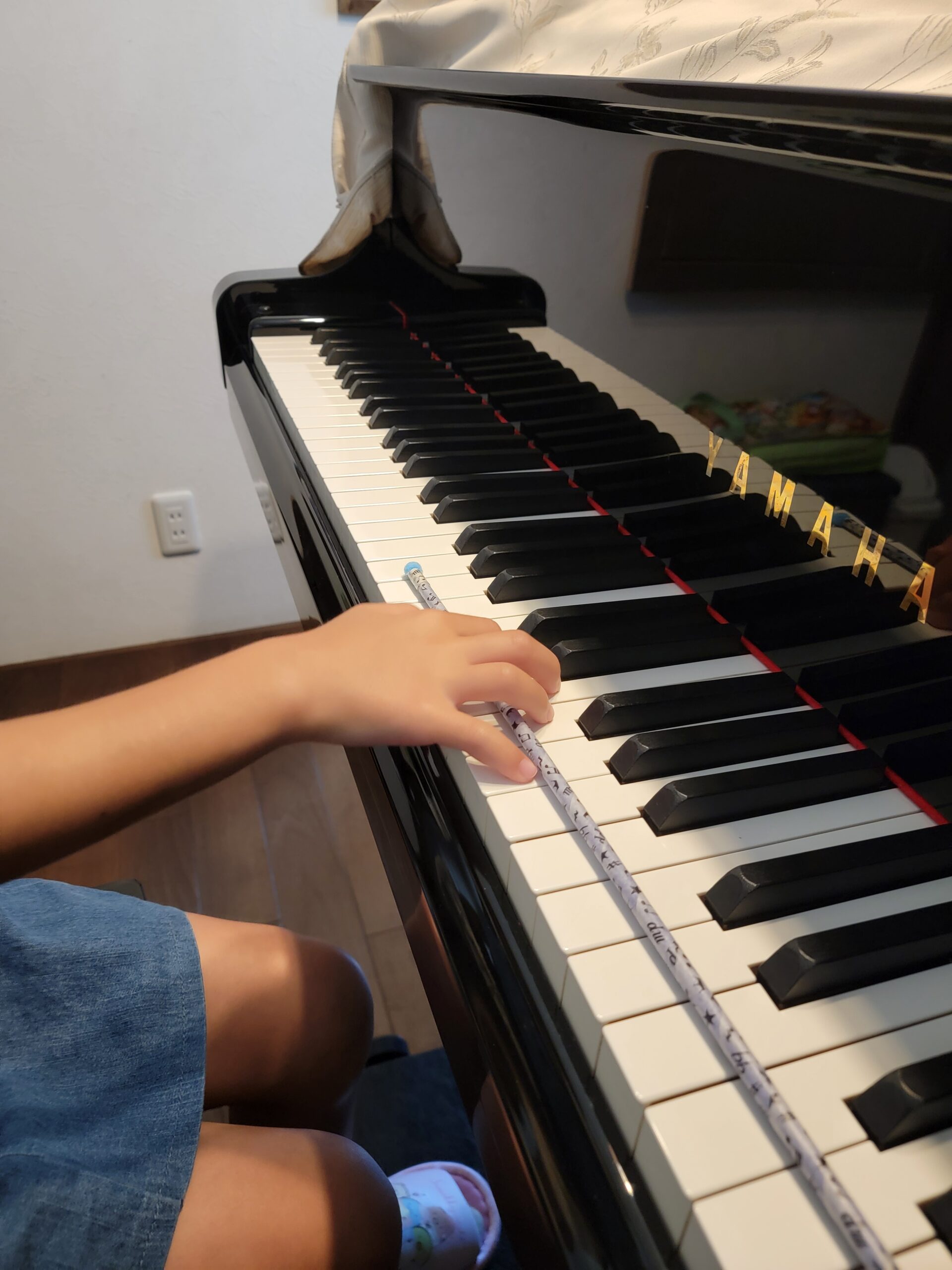 小山市のN piano music schoolで、ピアノ鍵盤上にスティックを置きながら指のポジショントレーニングを行う様子。