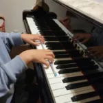 小学生の生徒が正しい手のフォームを学んでいるレッスンの様子