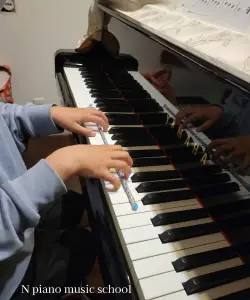 小学生の生徒が正しい手のフォームを学んでいるレッスンの様子