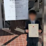 小山市のピアノ教室N piano music schoolの生徒が、ブルグミュラーコンクールに参加し、優秀賞を受賞。嬉しそうに賞状を持つ男の子の様子が収められている写真